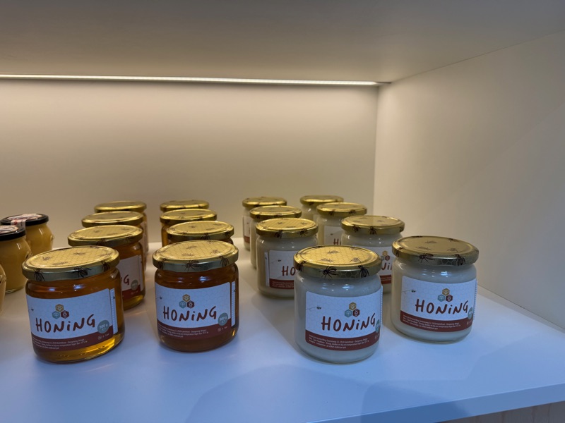 Potten vloeibare en gekristalliseerde honing in een rek